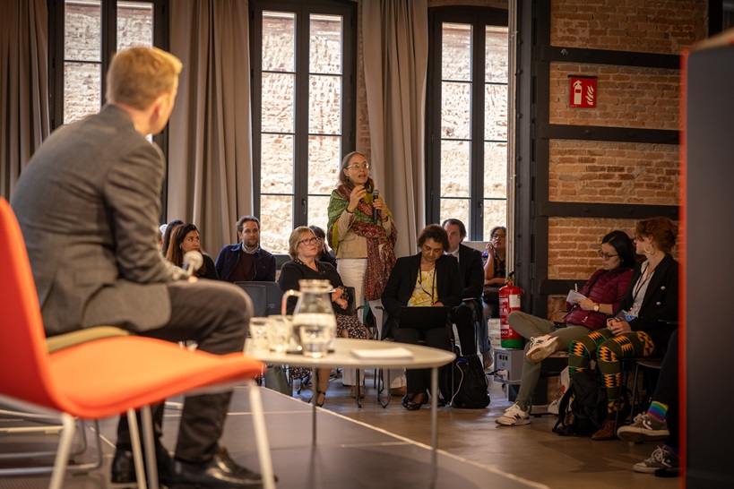 Photo of plenary session at OTT Conference "Unpopular Opnions", the facilitator David Watson is on the stage, one of the participants is sharing her unpopular opinion.